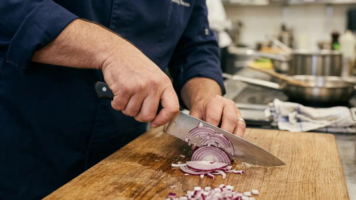 Tipos de facas de cozinha sendo utilizados por um cozinheiro profissional.